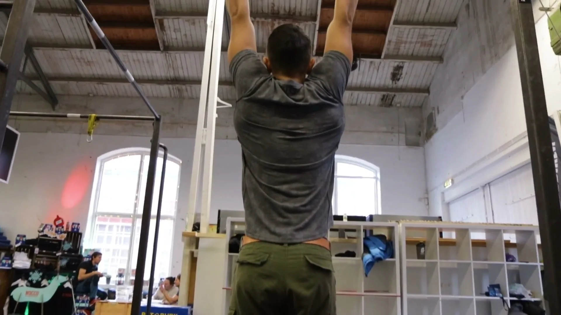 Dead hang on bar demonstrating grip strength requirement for calisthenics freestyle training
