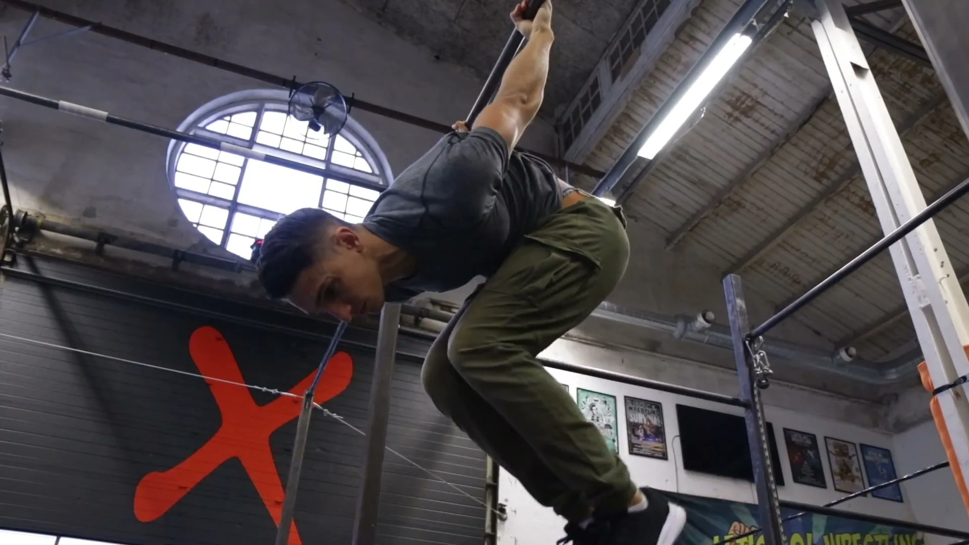 Skin the cat exercise on a bar showing shoulder flexibility and back mobility required for freestyle training