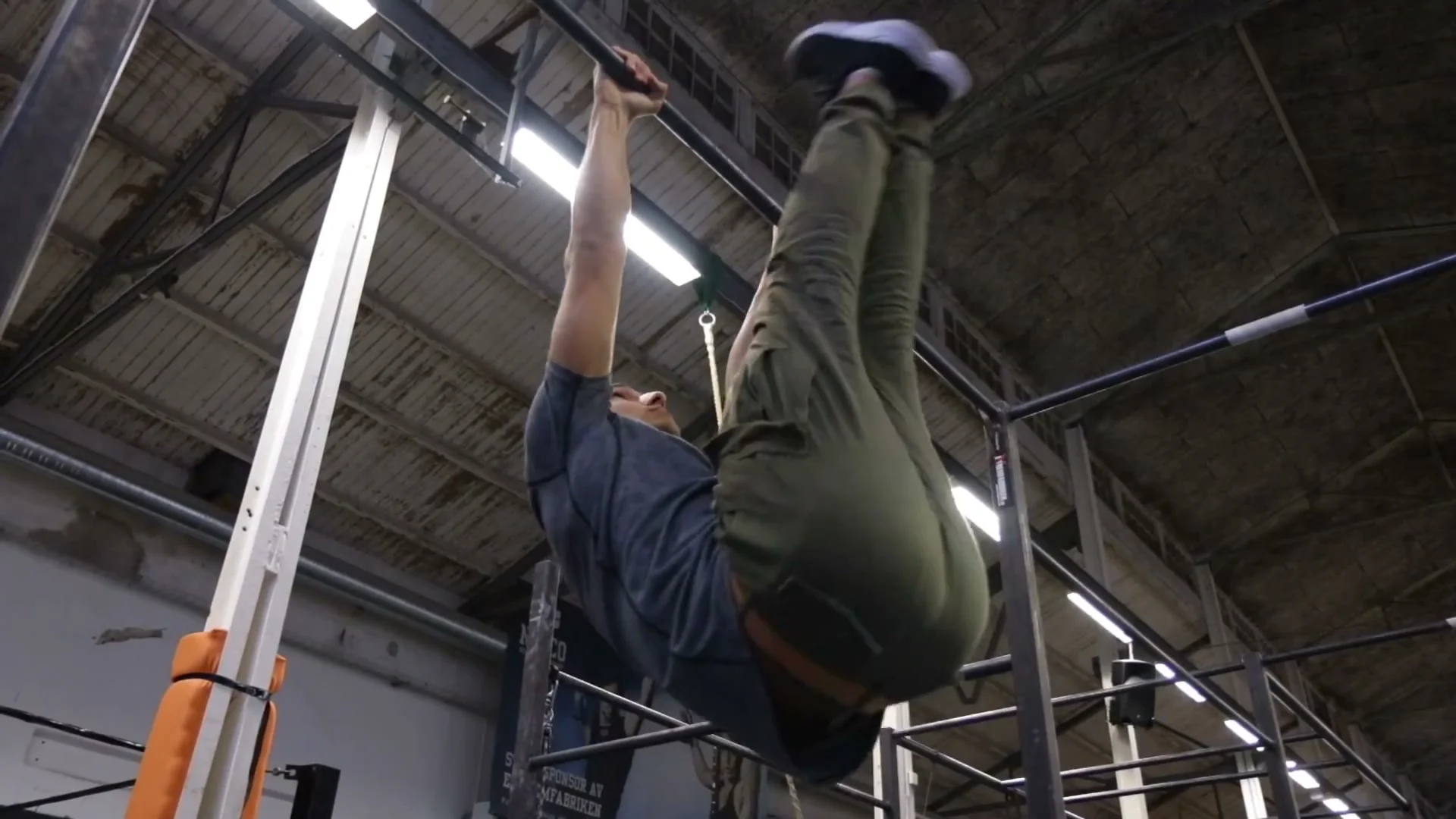Toes to bar exercise on a pull-up bar showing core strength for calisthenics freestyle requirements