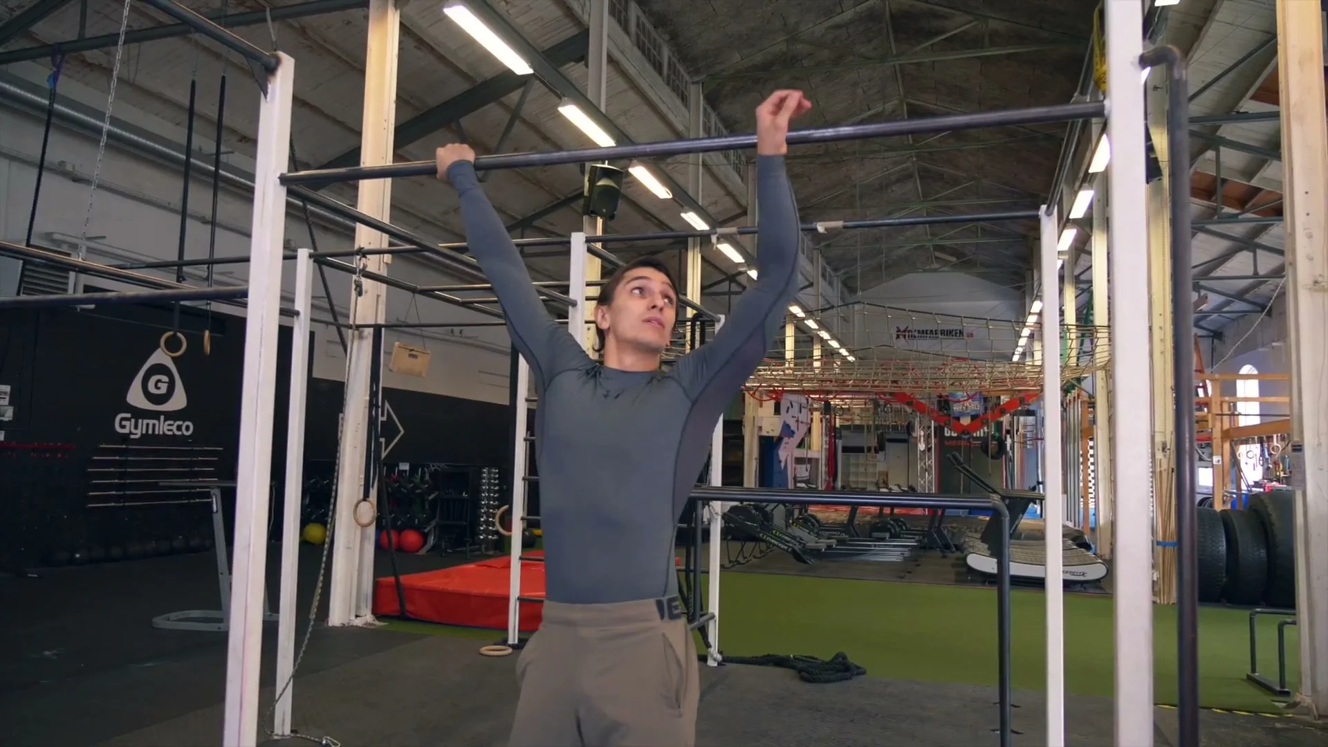 Daniel Flefil hanging from a bar in the dislocated grip: arms extended above and behind the head, wide grip, shoulders loaded in the reversed position