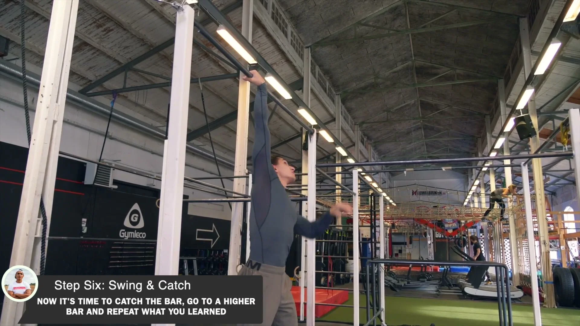 Daniel Flefil performing the dislocate 360 on a high bar: mid-spin with arms released from the reversed grip, full body rotation visible