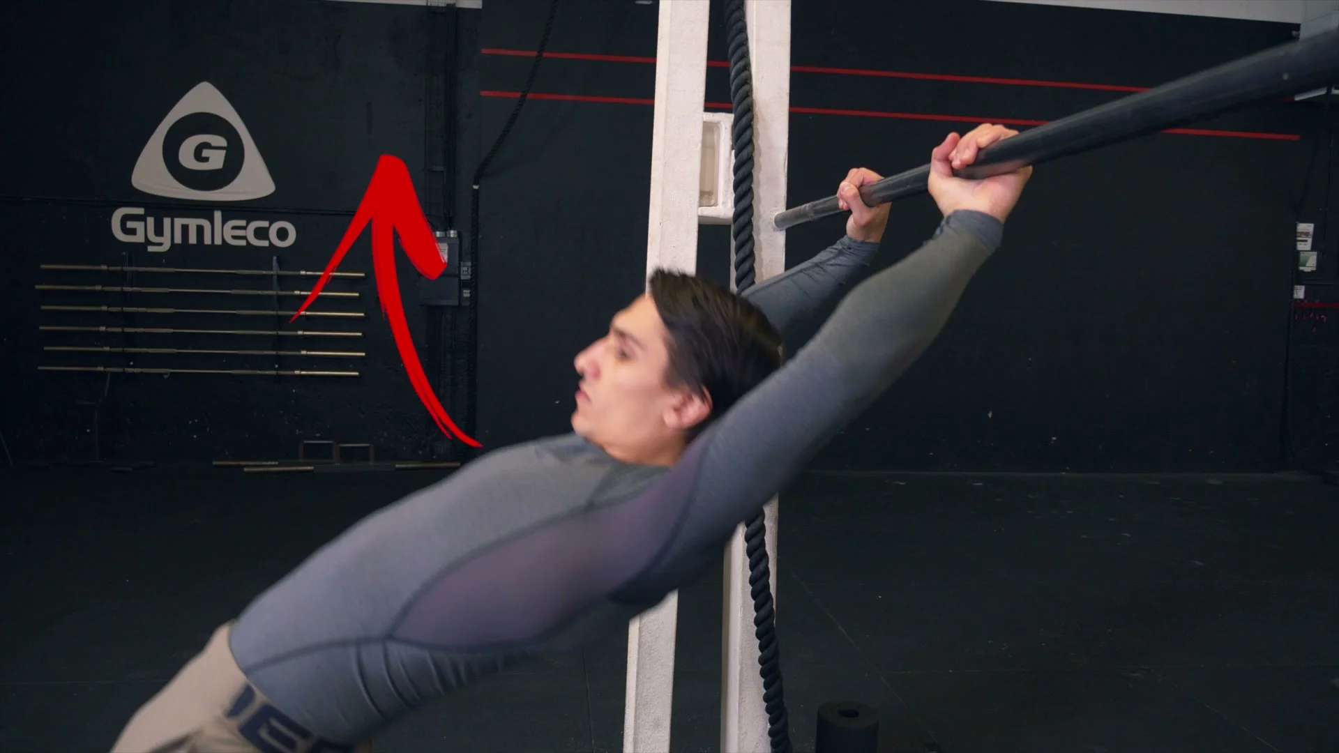 Daniel Flefil demonstrating the grip transition from normal to dislocated grip on a low bar: chest pushed up, body arched to switch the grip mid-swing