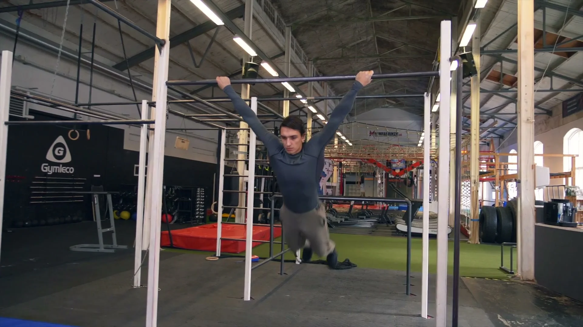 Daniel Flefil in the dislocated grip swing on a low bar: body extended at the bottom of the swing, building comfort with the reversed grip under dynamic load