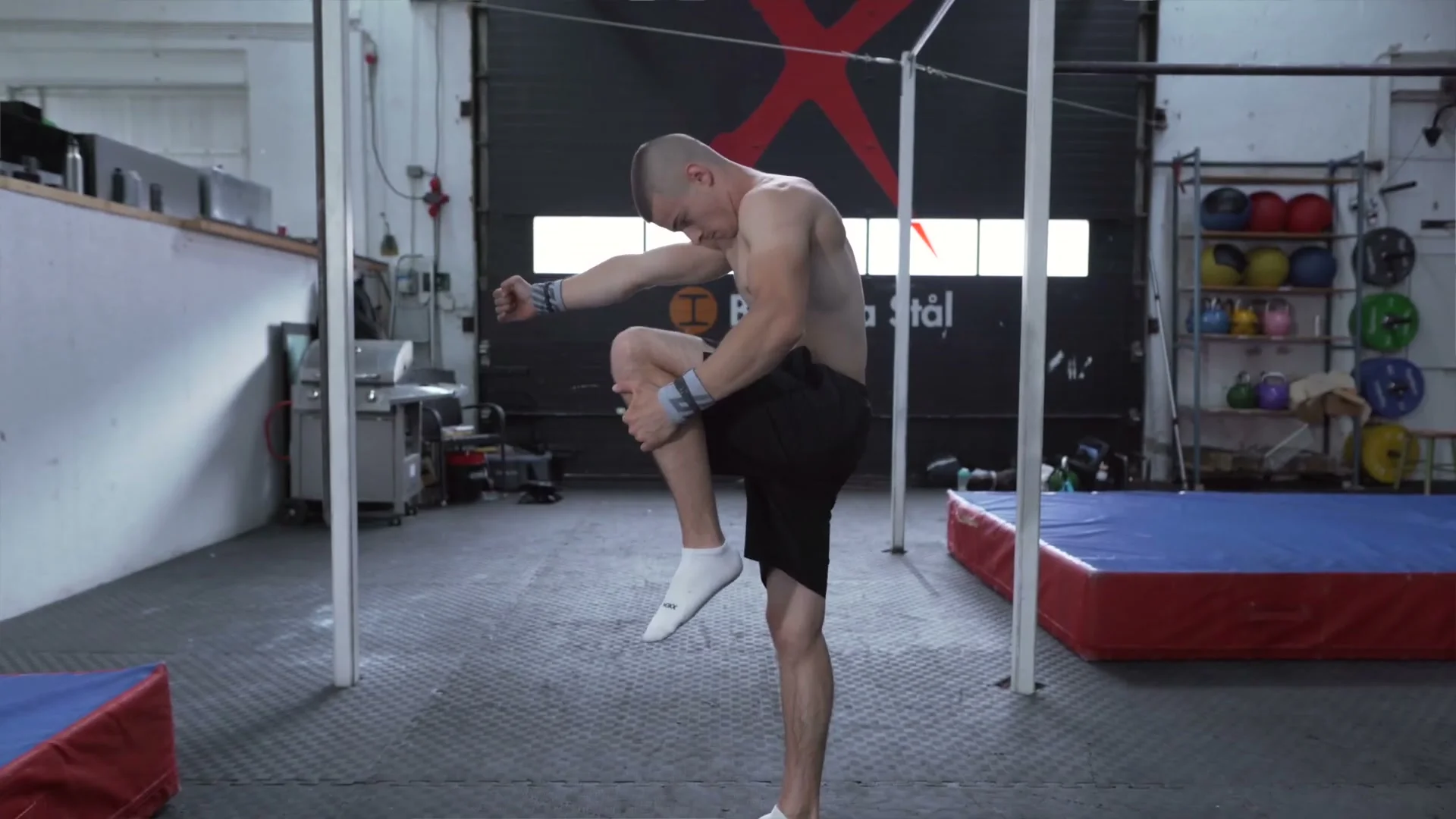 Daniel Hristov demonstrating the tuck position for the front flip on P-bars: body tucked with knees pulled to chest and head tucked, showing the tucking technique for the flip