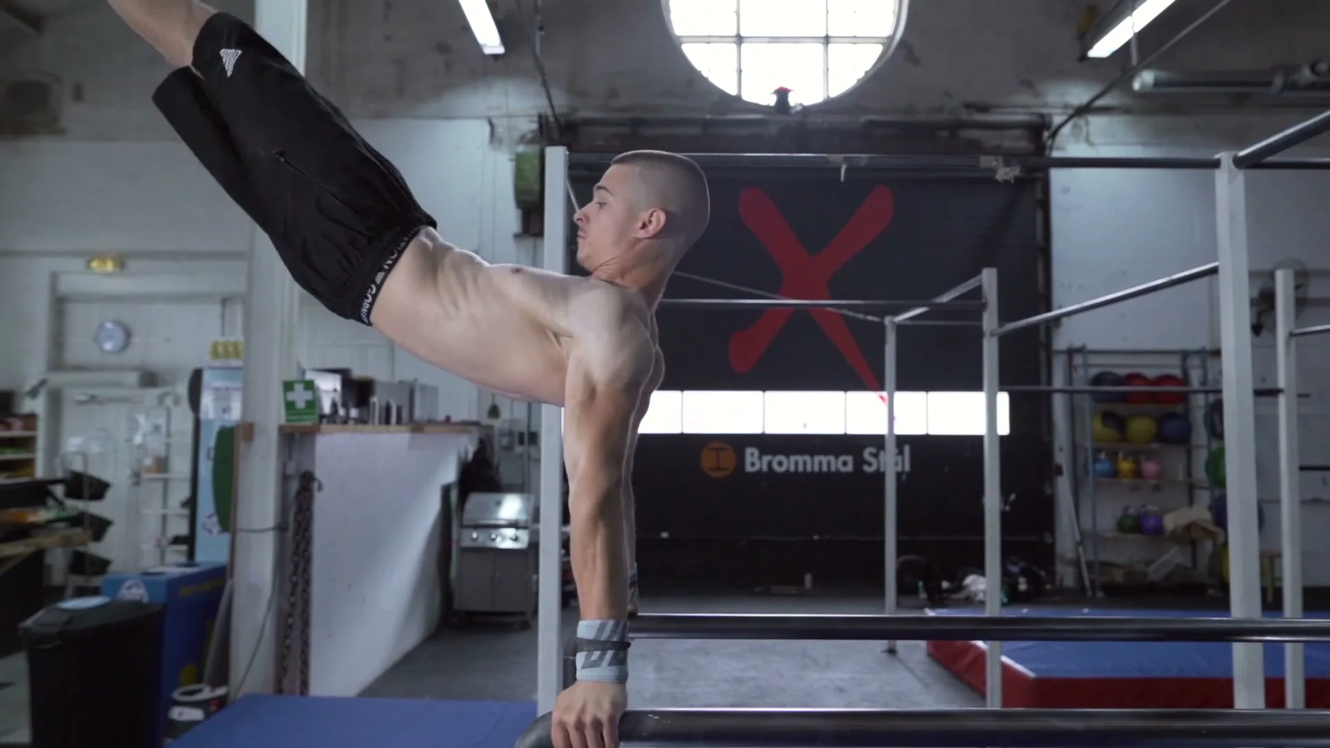 Daniel Hristov in the full front flip dismount from P-bars: body fully extended horizontally as he exits the bars, arms alongside the body mid-dismount