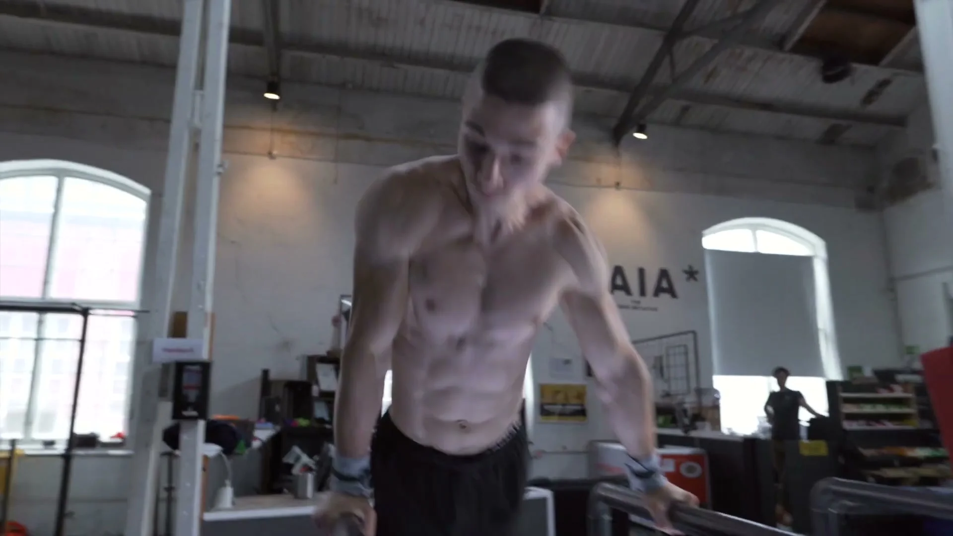 Daniel Hristov in the support position on parallel bars at the top of the P-bars, preparing for the front flip dismount tutorial