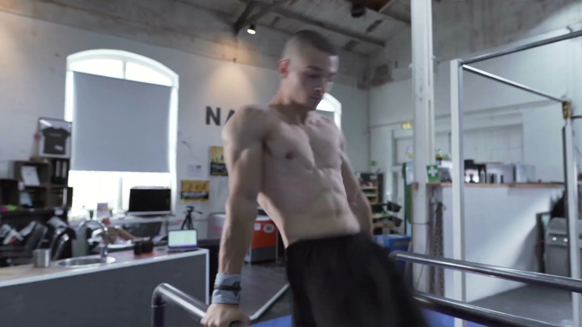 Daniel Hristov on parallel bars during the jump outside step: standing on the bars showing the position after exiting the P-bars during the practice of the lateral jump dismount