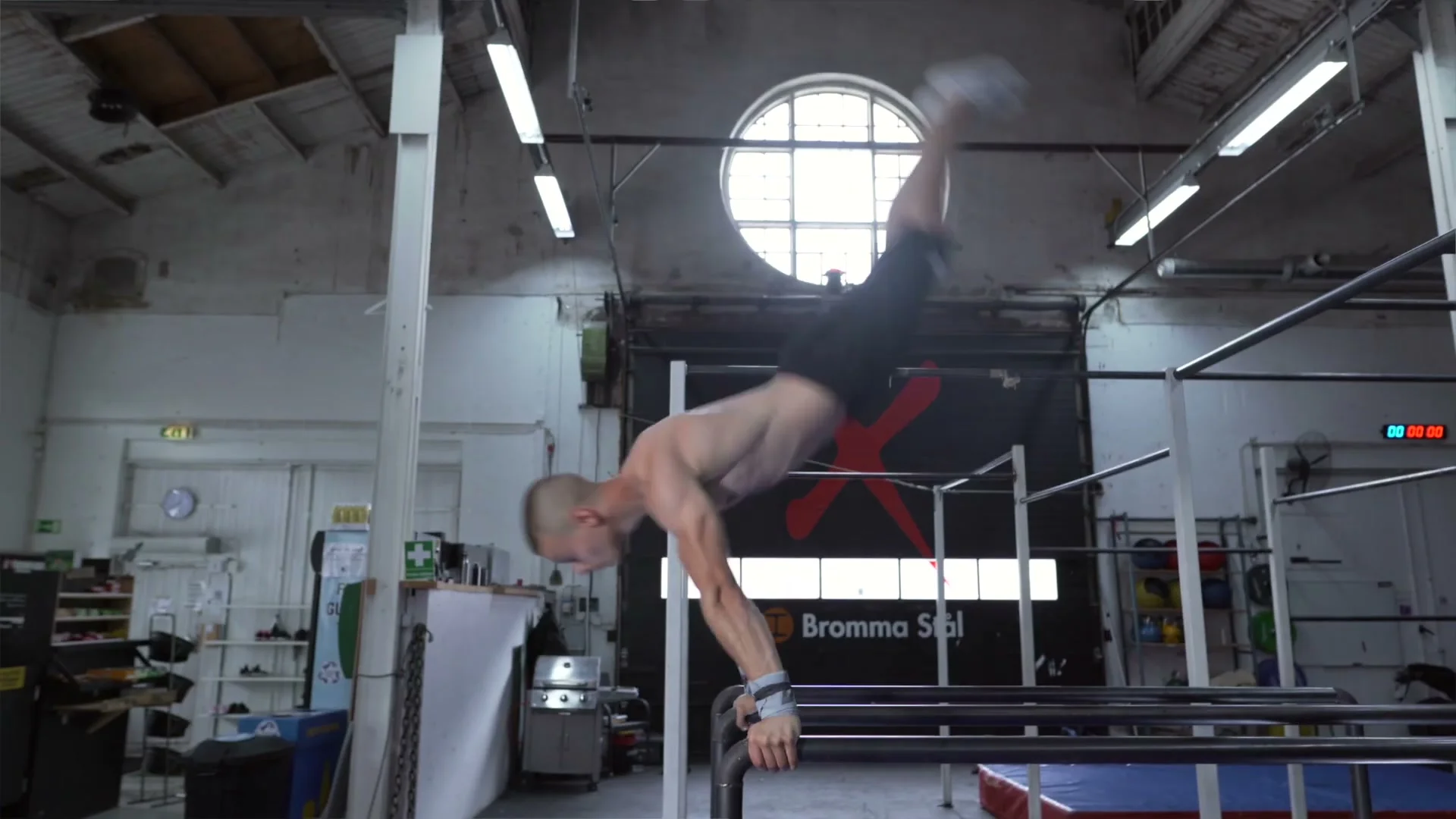 Daniel Hristov swinging to near-handstand position on the parallel bars: body nearly inverted with straight arms and straight legs, demonstrating the swing-to-handstand step