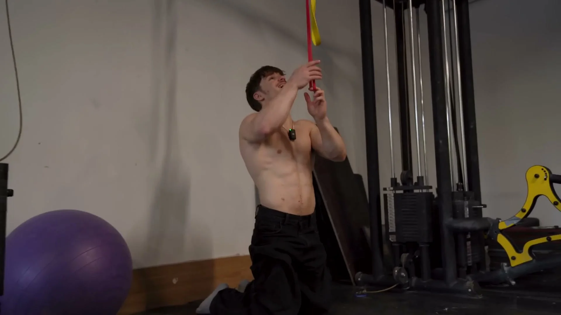 Nathan Bosech demonstrating elastic band lat activation drill on knees for front lever training