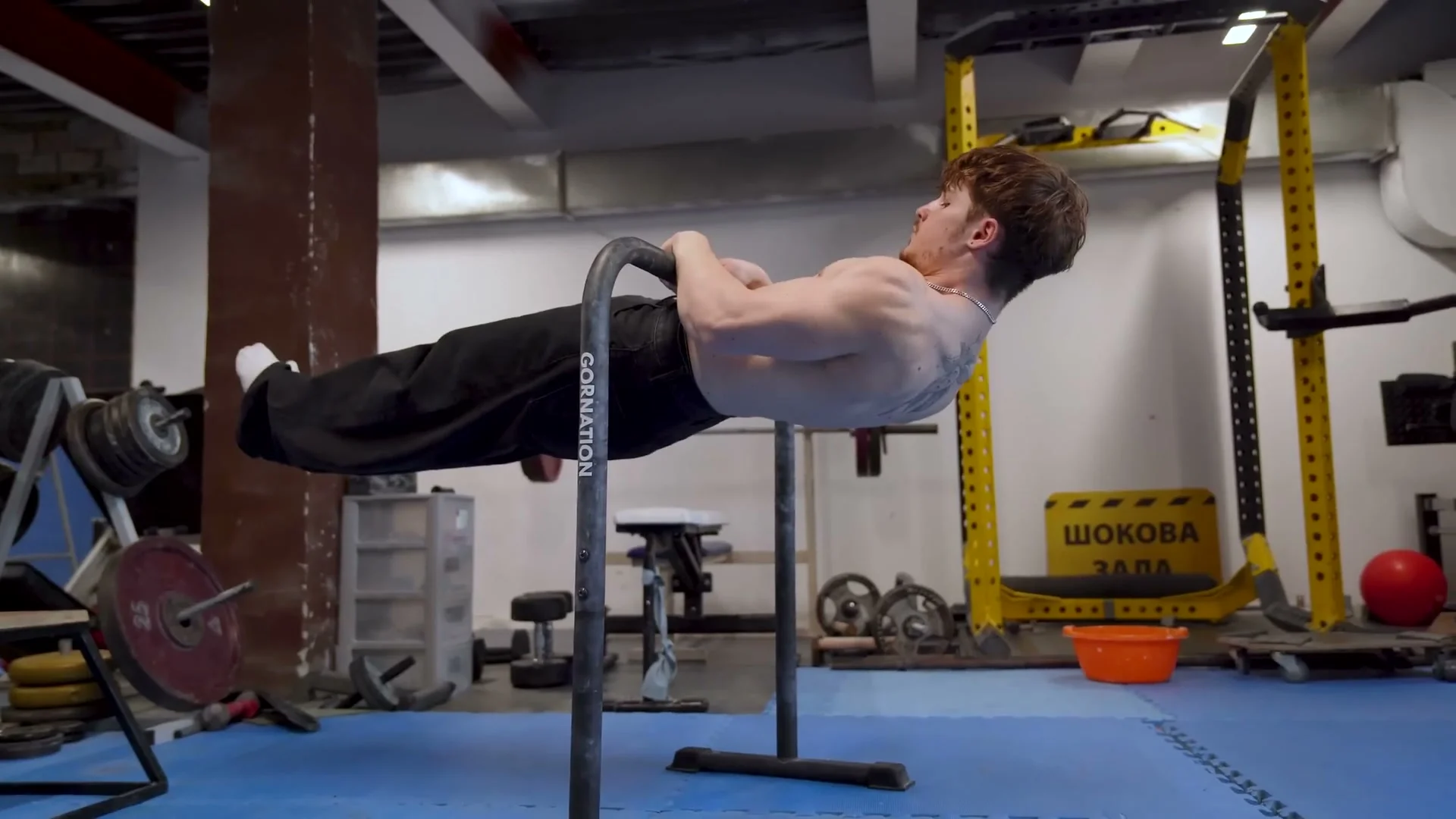 Nathan Bosech performing a front lever pull-up, demonstrating the breathing and bracing technique