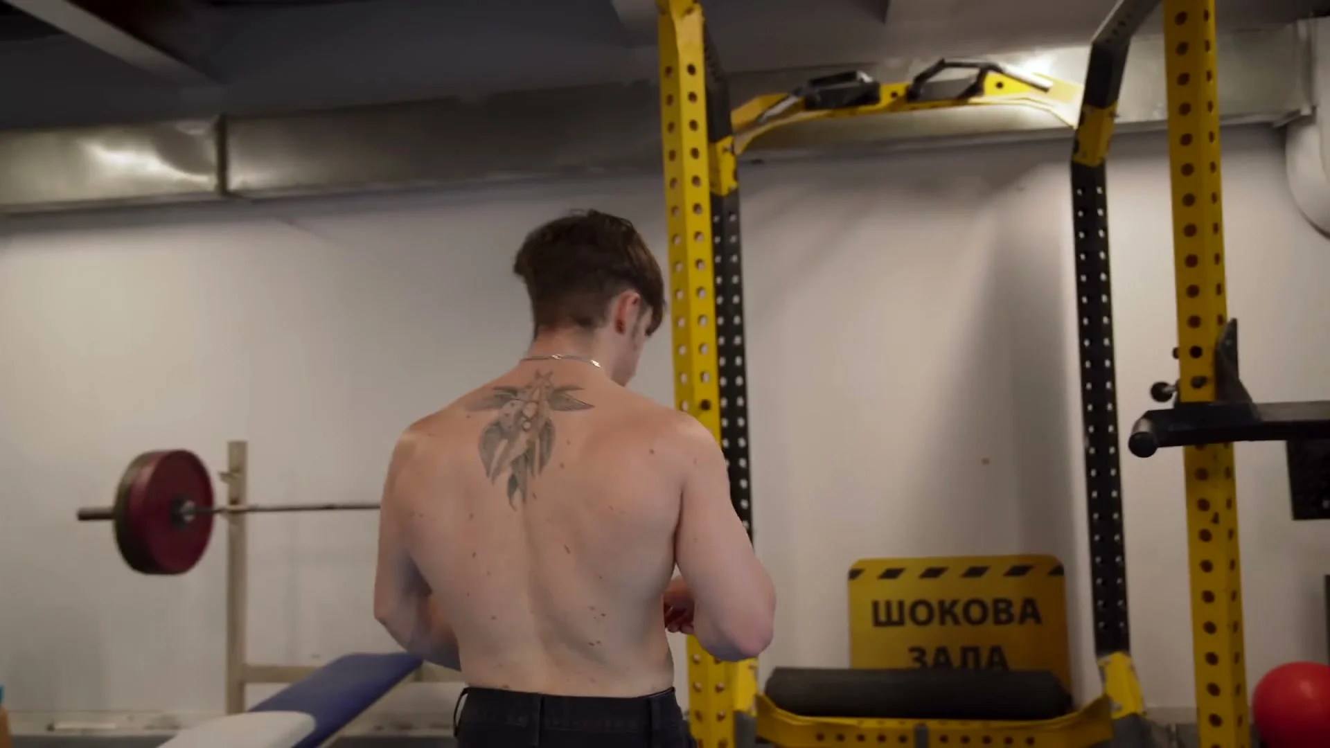 Nathan Bosech hanging from a pull-up bar performing scapular retraction drill for front lever activation
