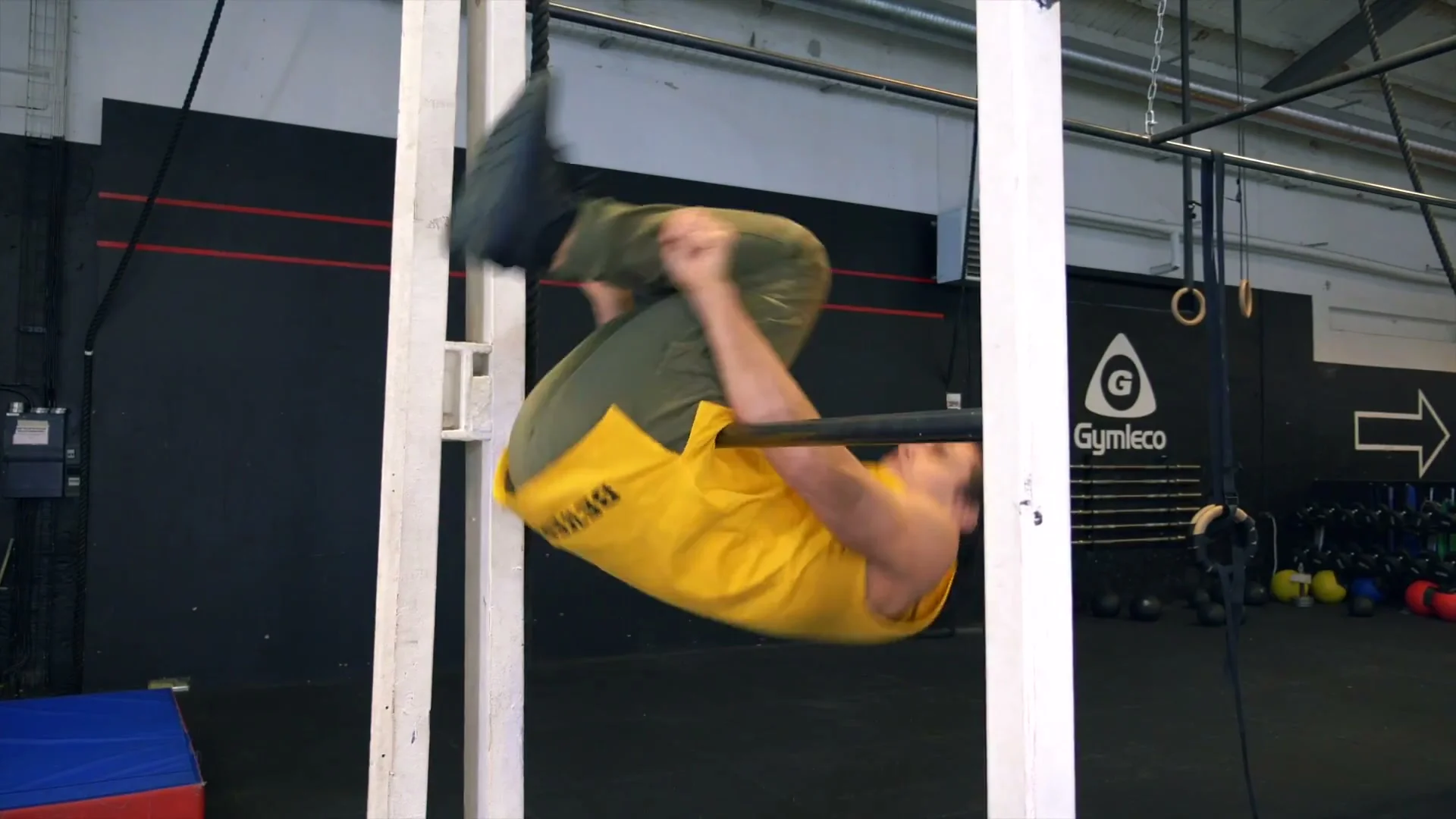 Daniel Flefil performing the front roll on the bar: body inverted with legs coming over, hips on the bar at the midpoint of the forward rotation