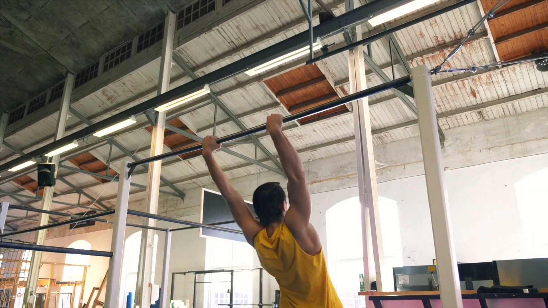 Daniel Flefil hanging from the high bar before the dynamic muscle up that leads into the front roll combination at a gym