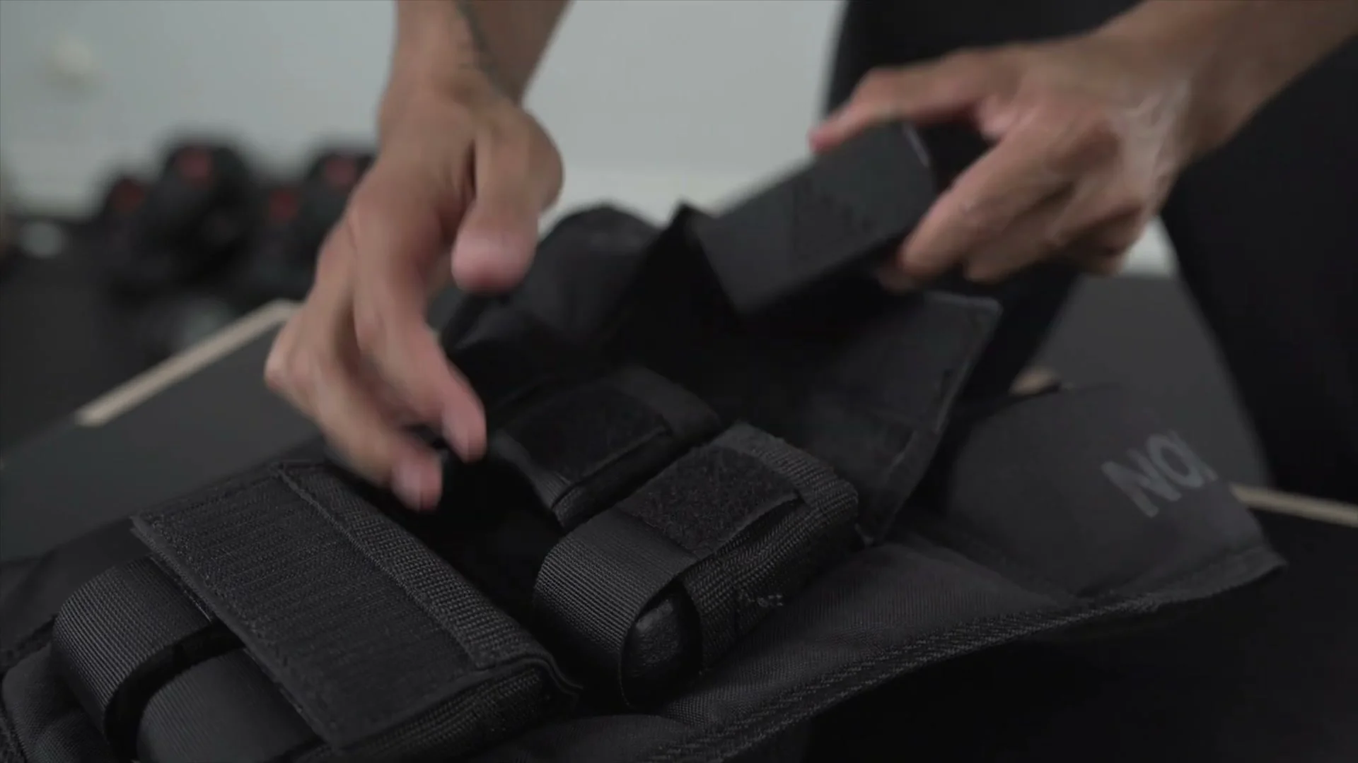 Daniel Flefil demonstrating removal of individual weight plates from the GORNATION vest