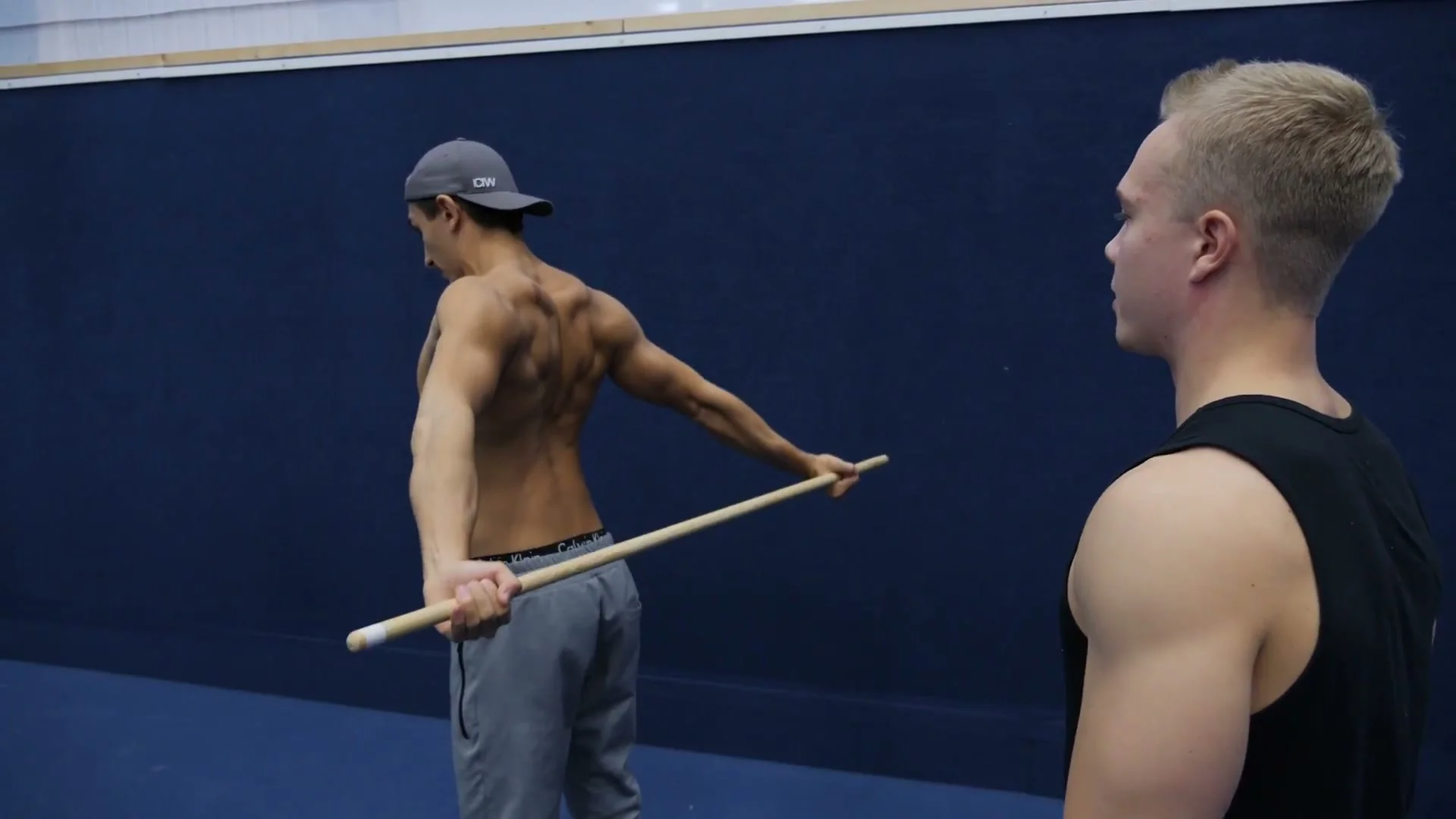 Shoulder dislocate form detail: stick at the back position with arms straight and scapulas squeezed together, stiff back version for shoulder flexion training