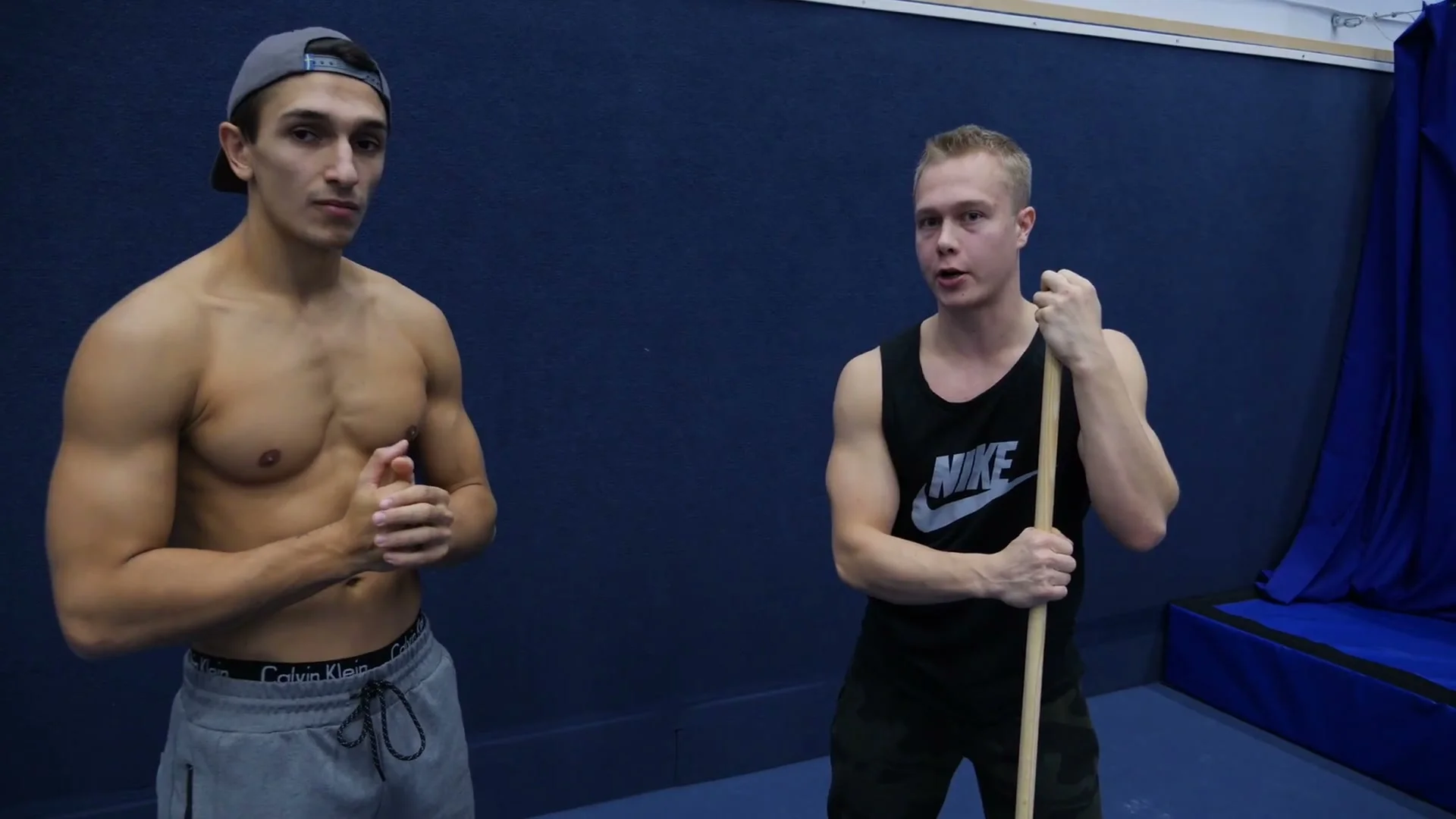 Shoulder dislocate exercise for hollowback: stick held overhead and brought back behind body to train shoulder flexion range