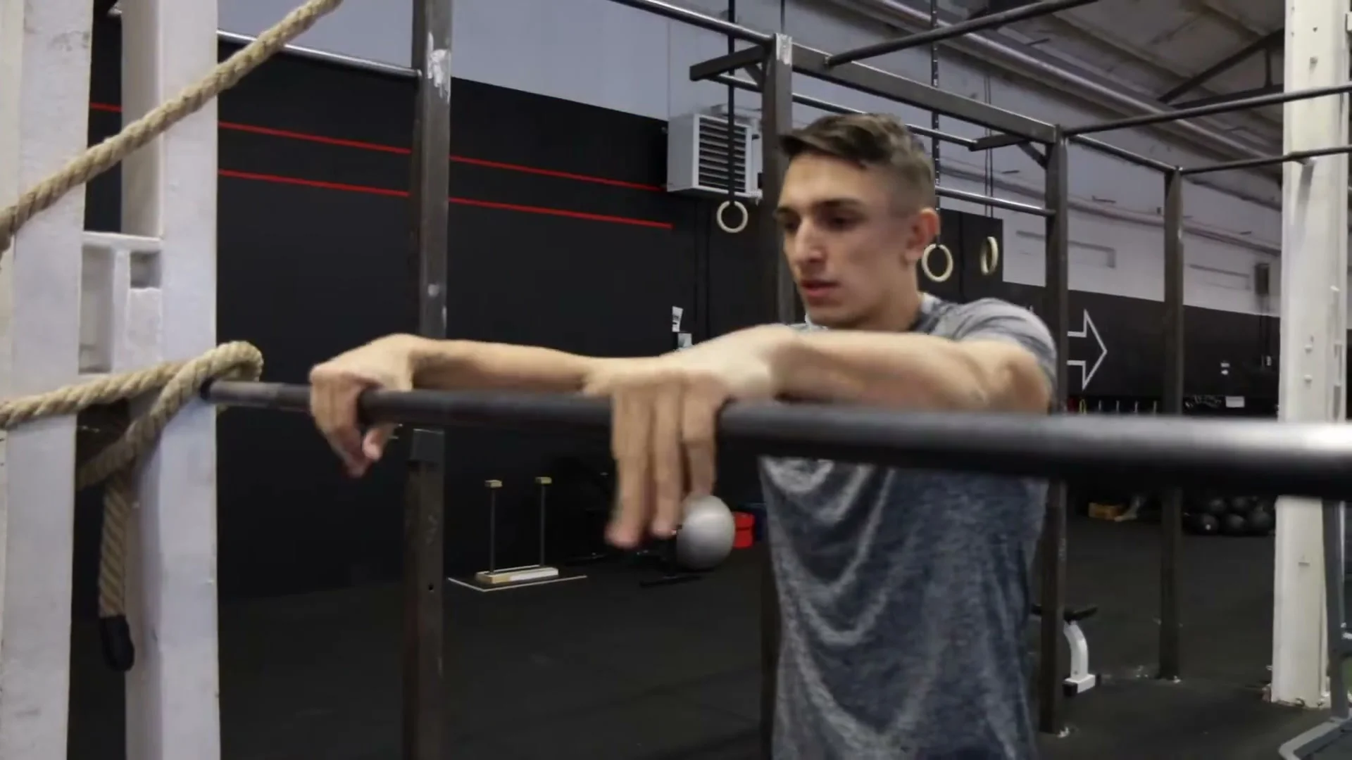Close-up of correct grip on a pull-up bar showing thumbs wrapped around the bar and hands positioned just beside the hips