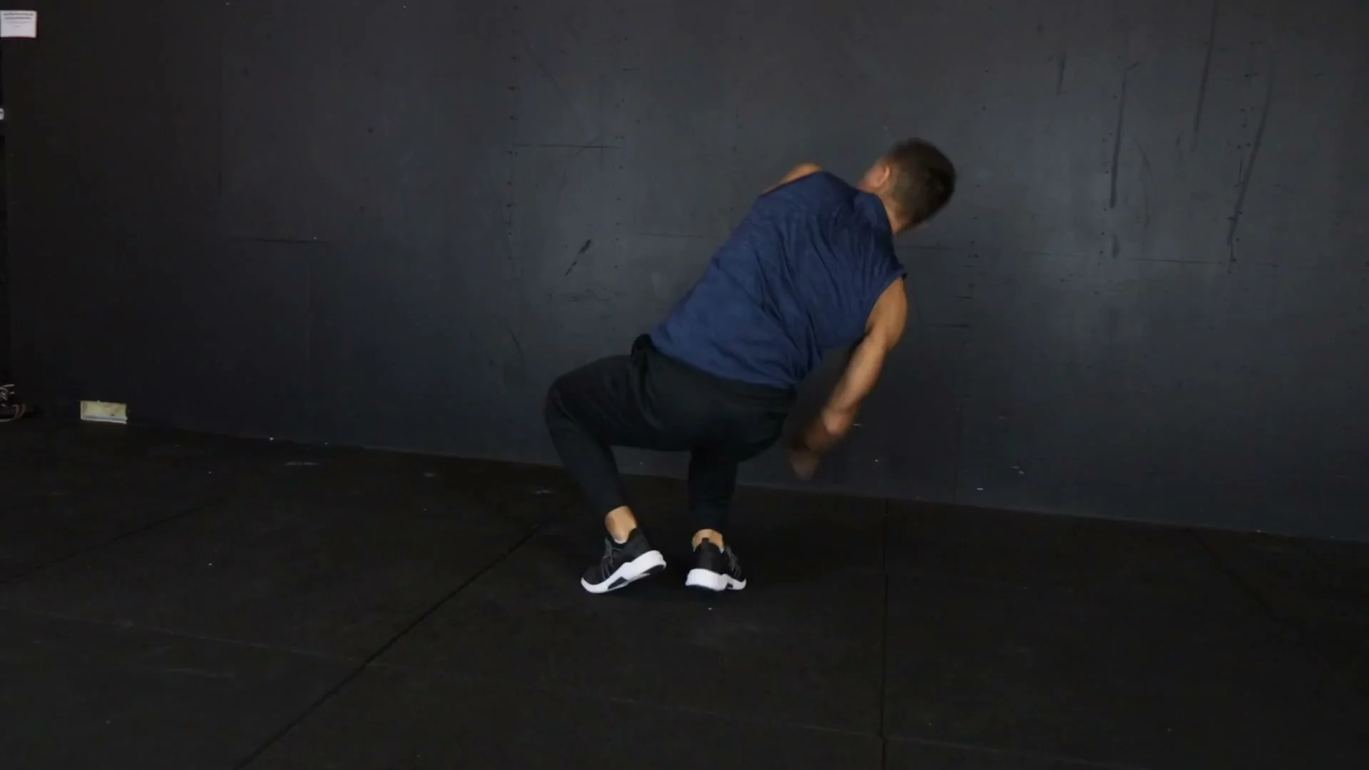 Landing phase of the push-up 360 showing the squat-like landing position before returning to push-up stance