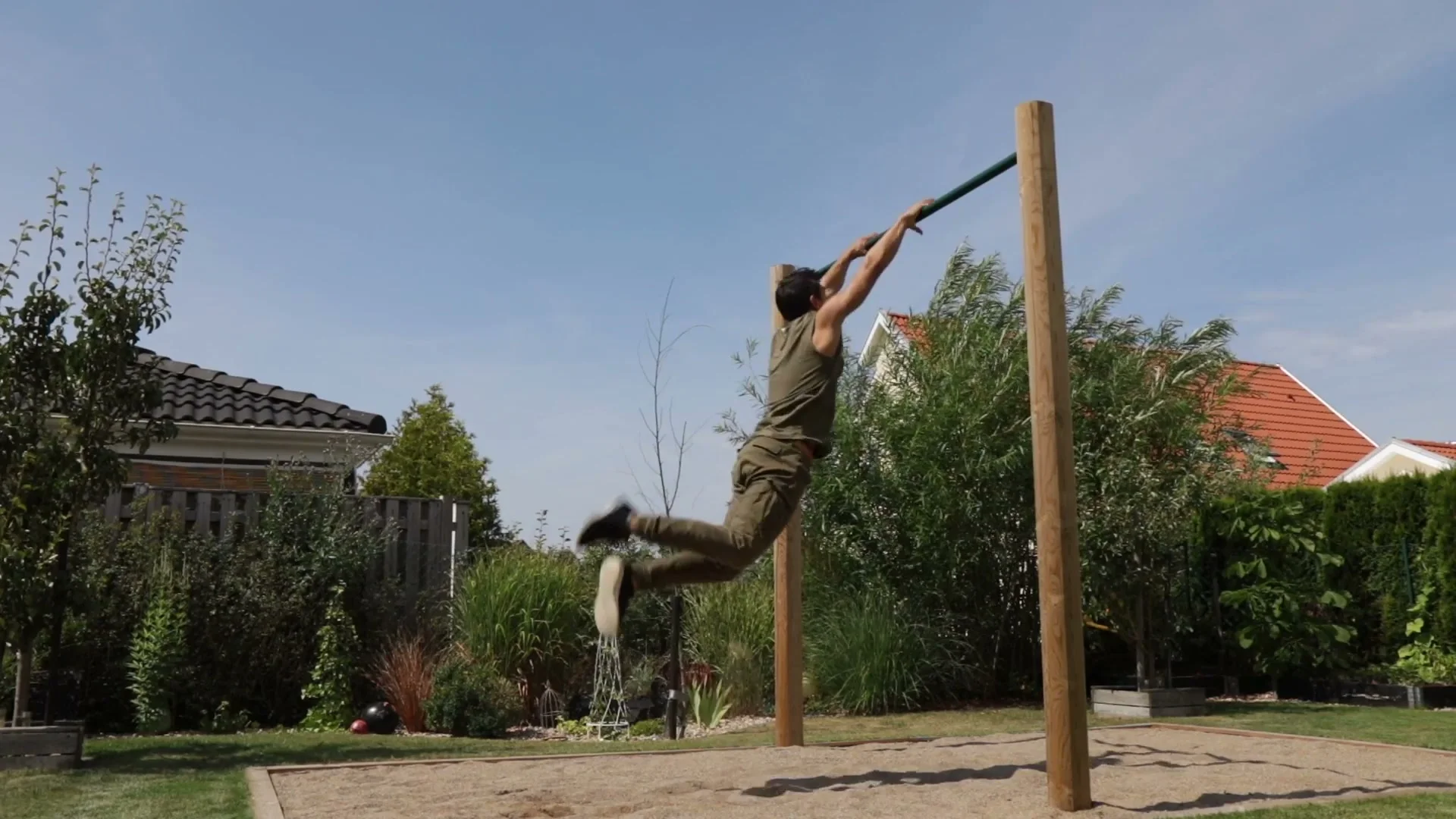 Daniel Flefil performing the shrimp flip on an outdoor bar, body in mid-flight after the kick-out during the full re-catch movement