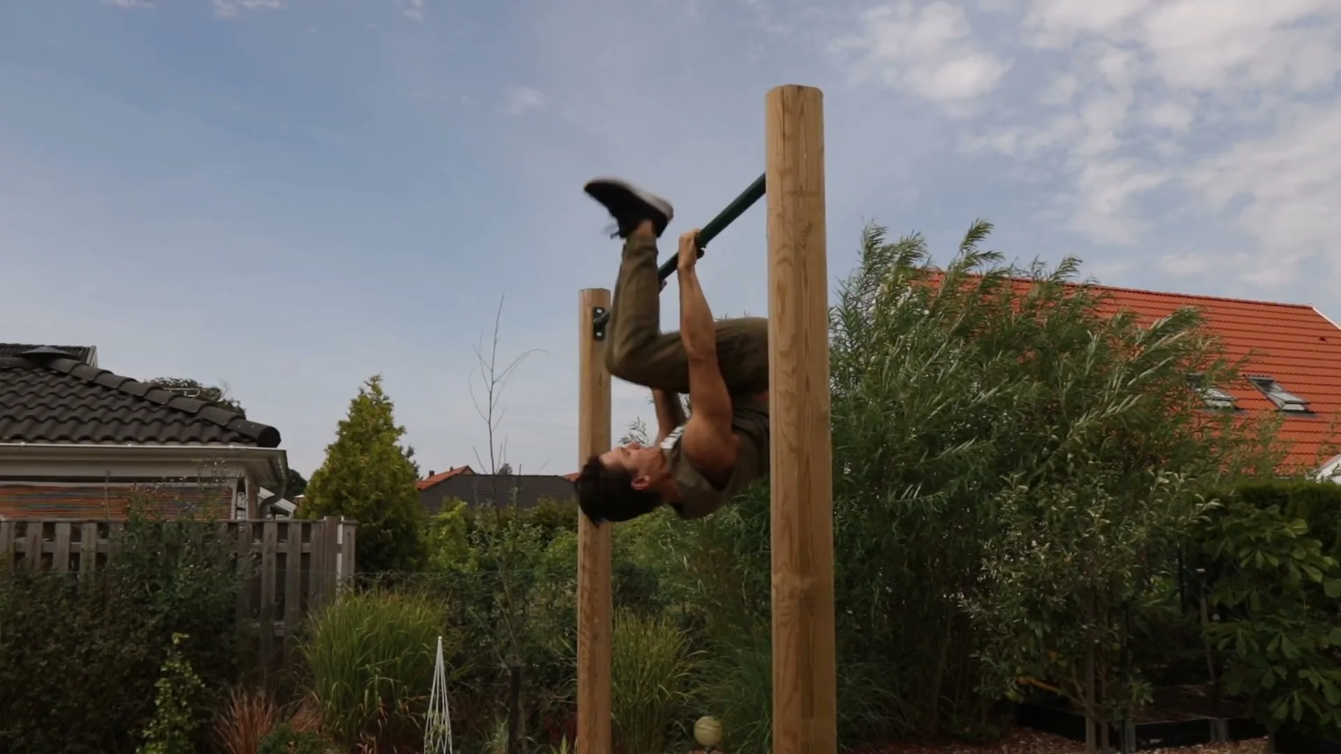 Kick-out drill for the shrimp flip: body inverted on bar with legs kicked up toward the sky, heels aiming upward in the upside-down deadlift position