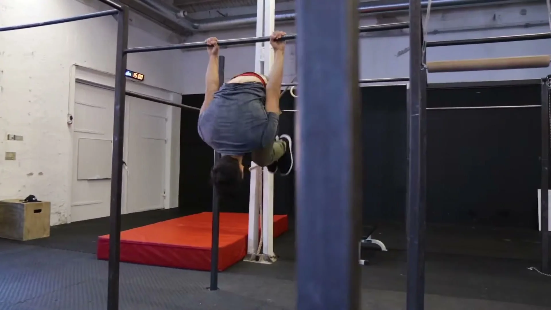 Daniel Flefil in the inverted skin the cat position on a bar, demonstrating the prerequisite movement for the swing gainer