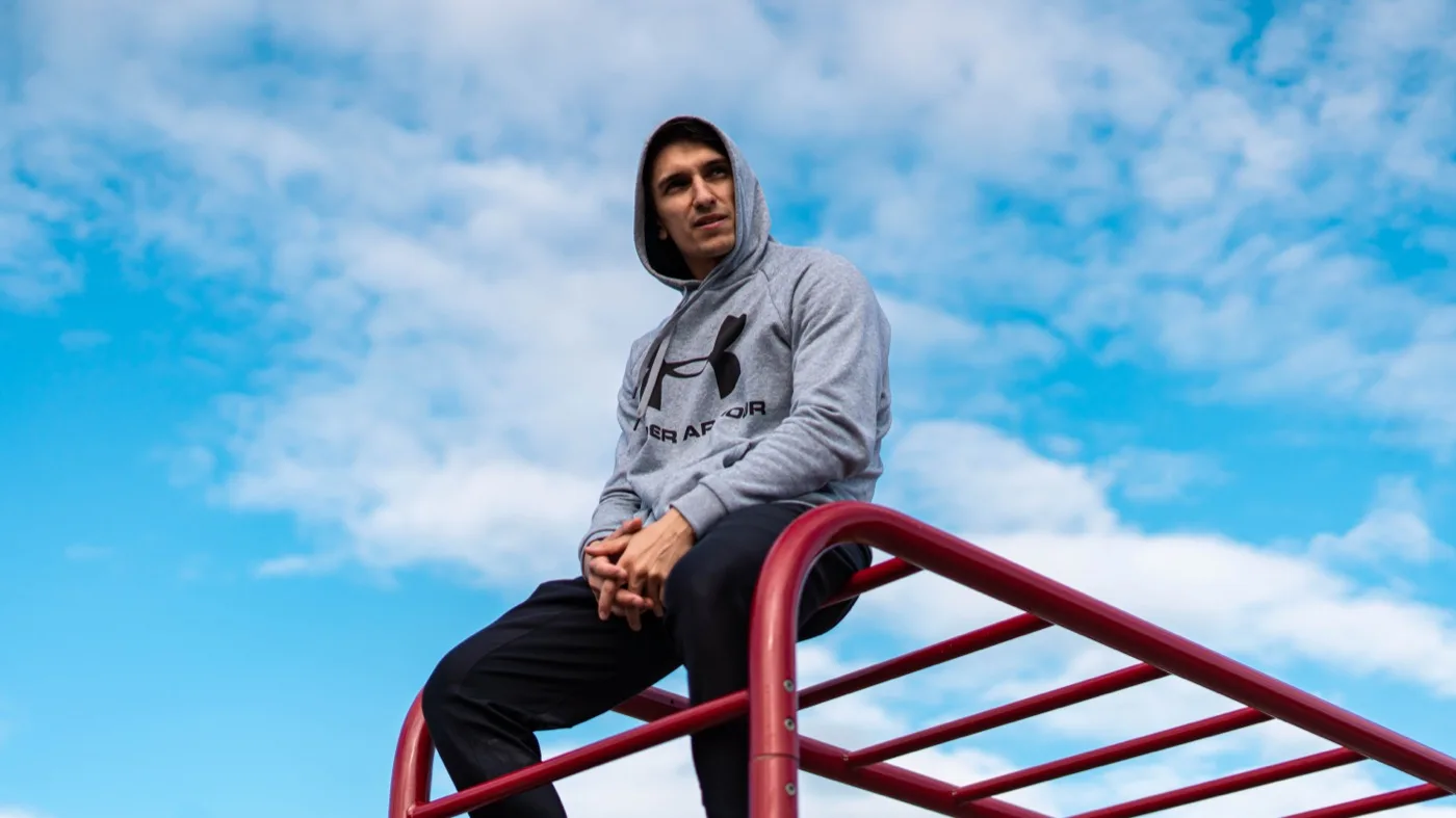 Daniel Flefil performing on outdoor calisthenics bars at a park